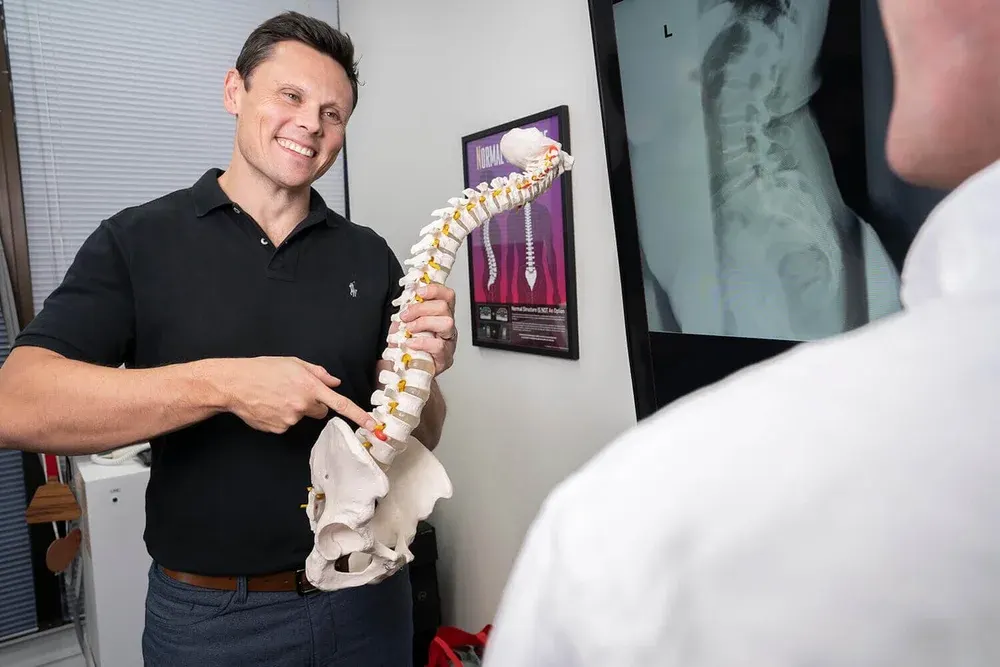 Chiropractor reviewing a spinal x-ray with a patient
